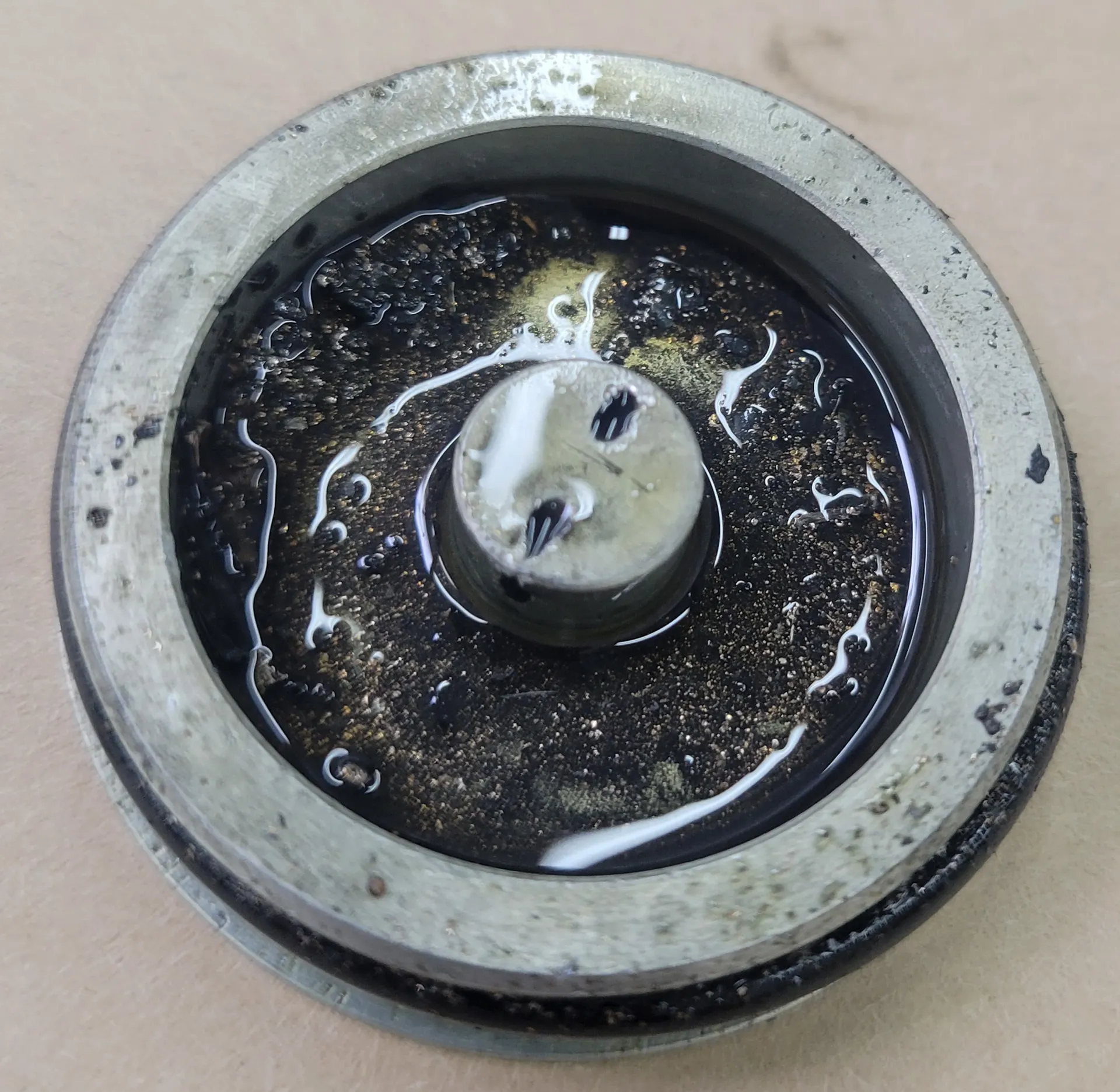 Appendix 3. Pictures of damaged ACM parts. Oil cap with particles and residual oil.