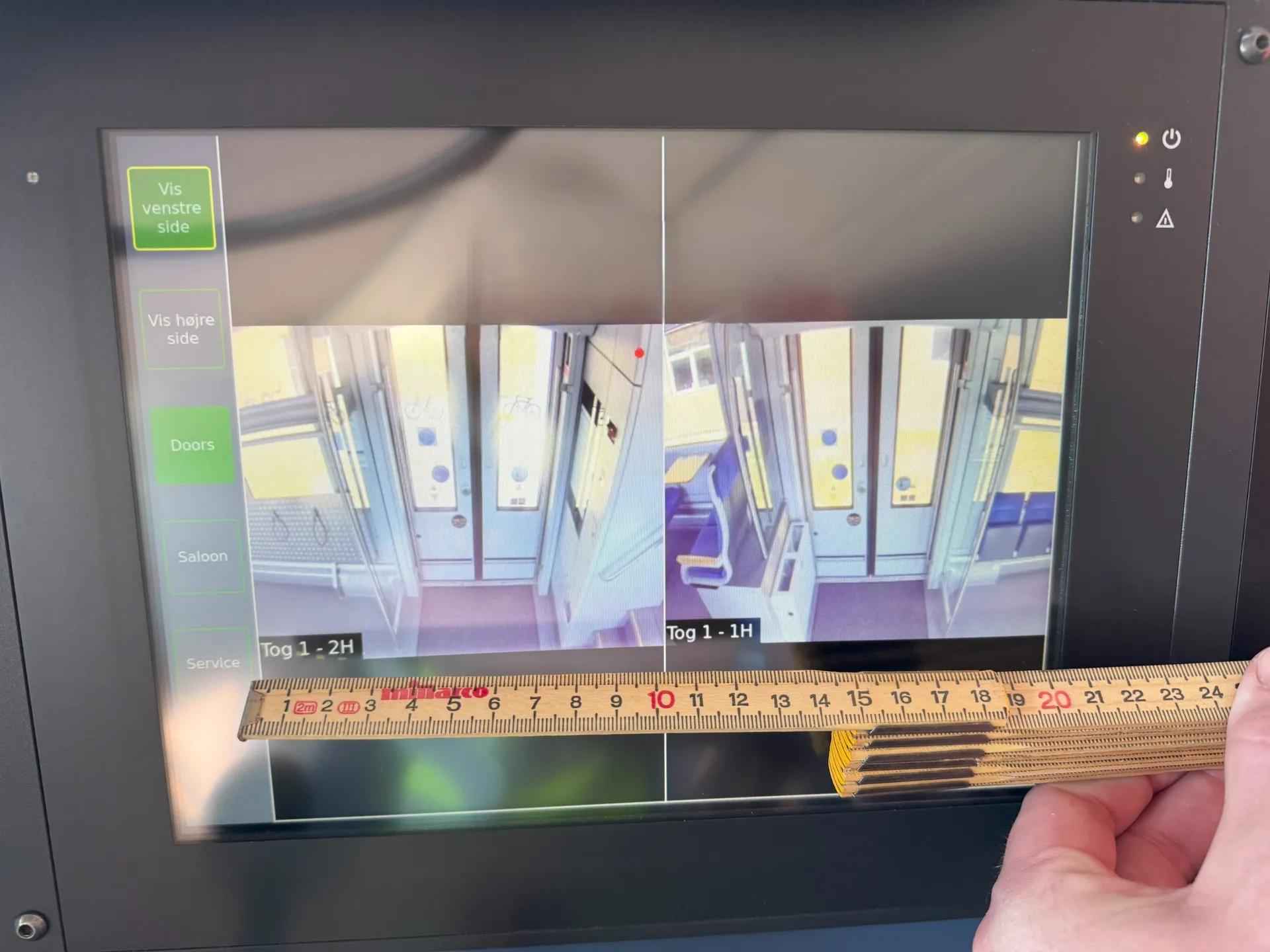 Skærmen i førerrummet opmålt med tommestok.